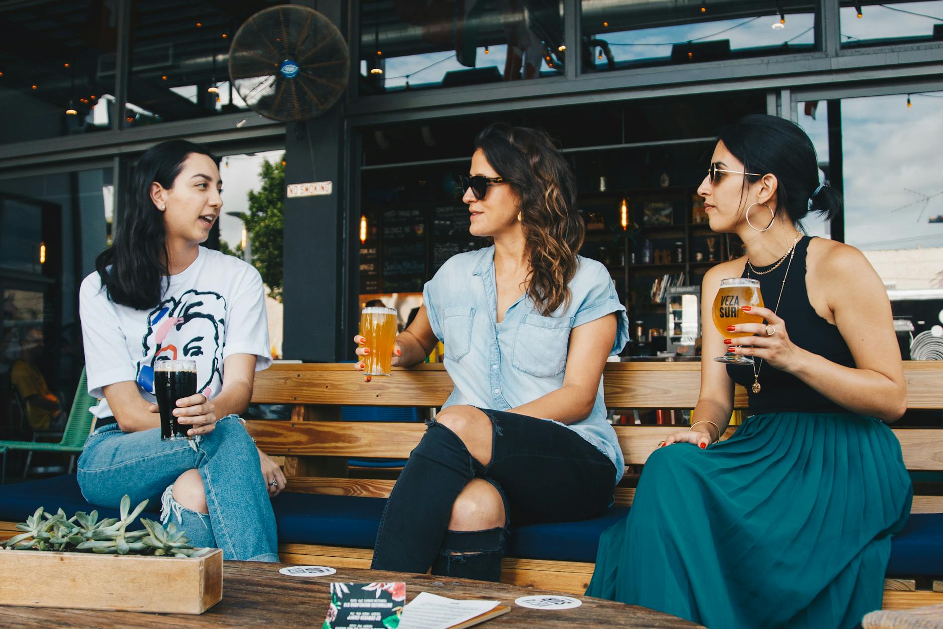 three women holding clear glasses